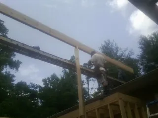 Carpenter setting a ridge beam over a new addition frame — Ice Dam Removal by Roofing Brothers in Salters