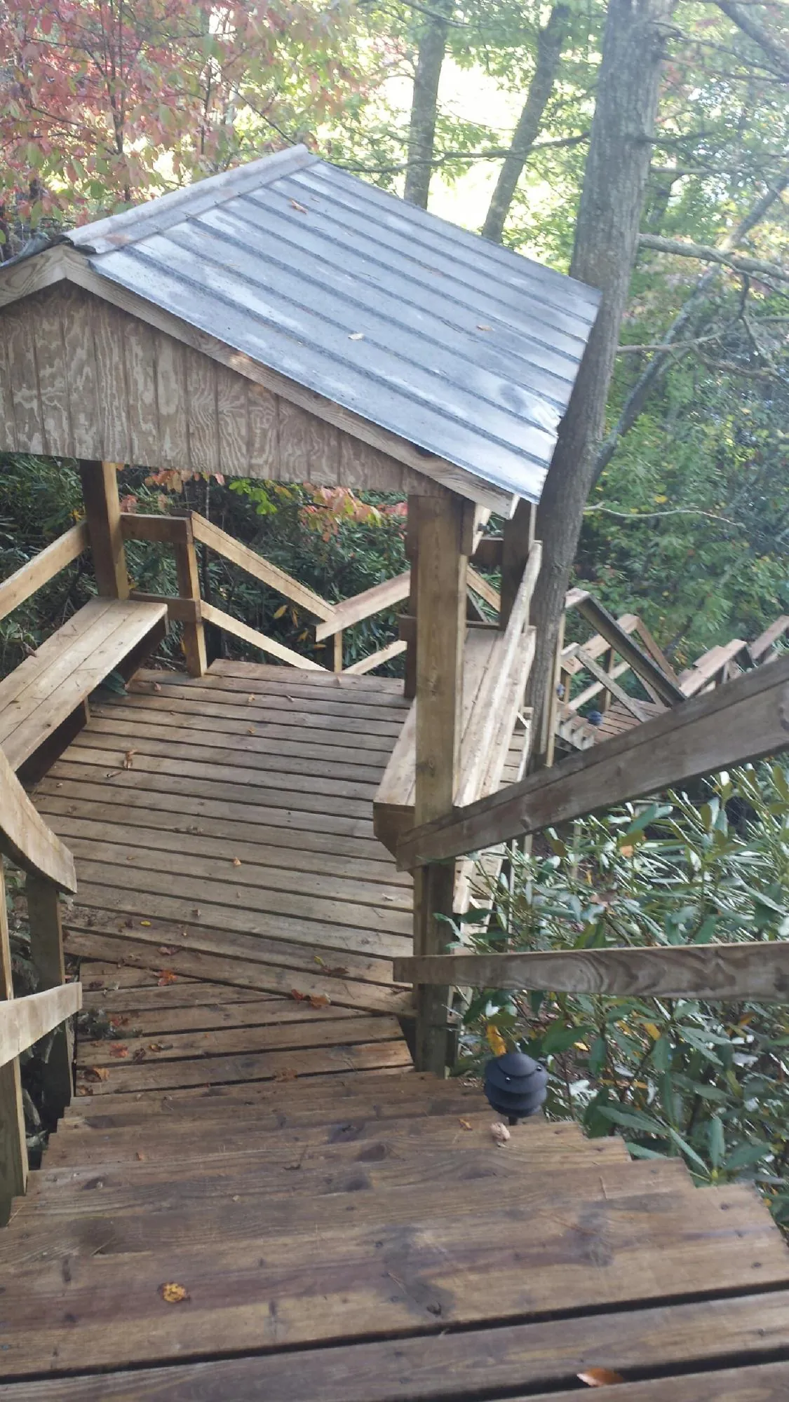 Metal roofed shelter over wooden steps on a wooded walkway — Skylight Repair & Installation work by our crew in Salters