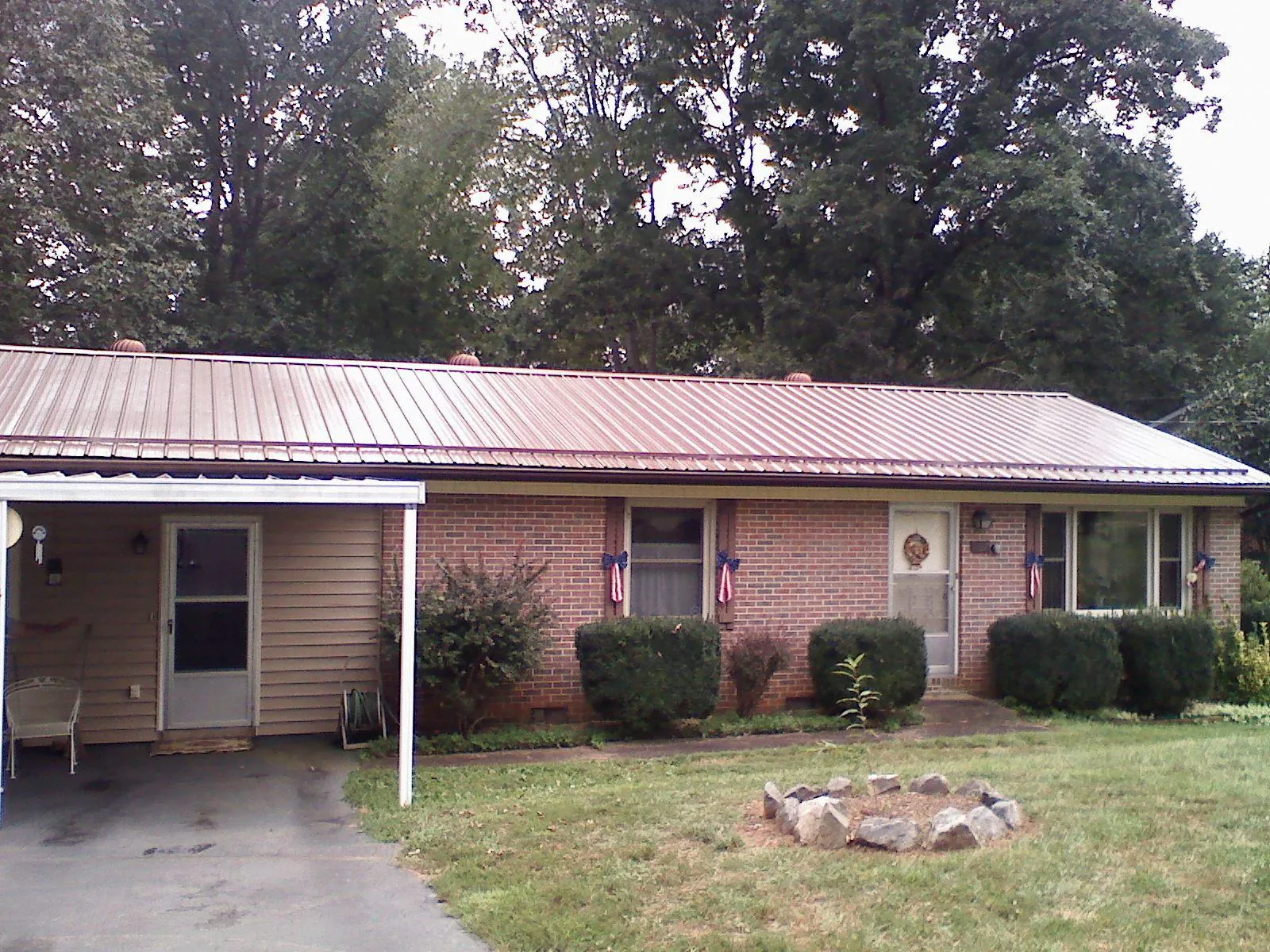 Bronze metal roof and carport on a brick ranch home — Roof Repair work by our crew in Salters